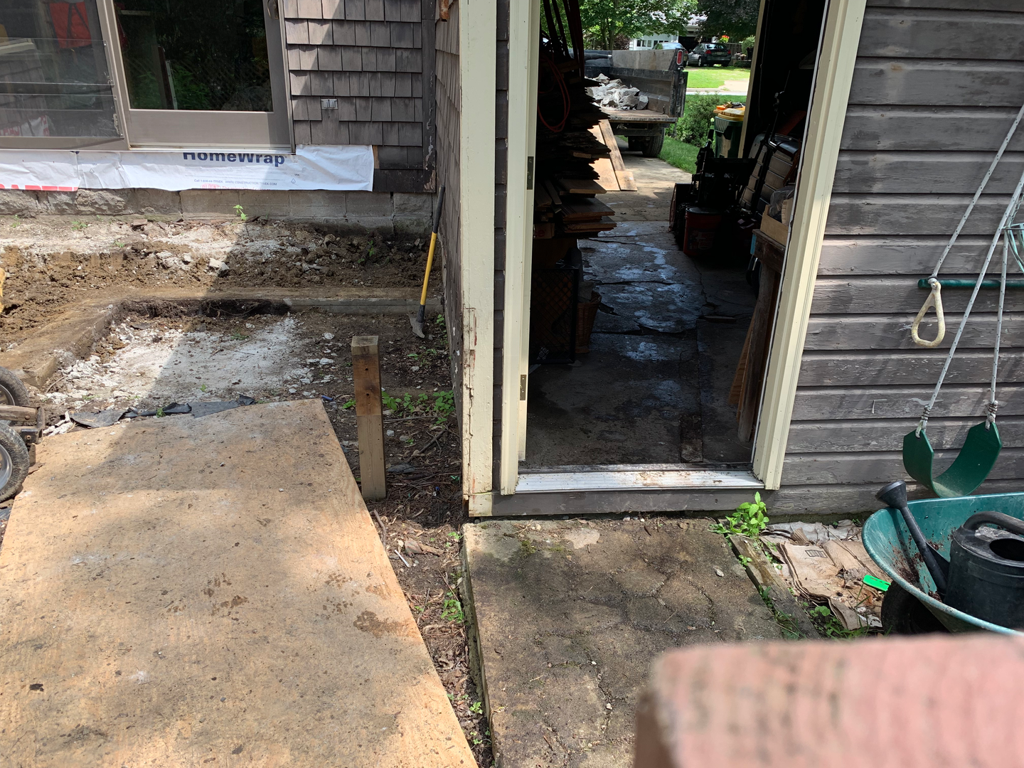 Here's the setup: concrete on the left (mostly gone in this picture), huge step into the garage, then up a ramp into a dump trailer, on the right.
